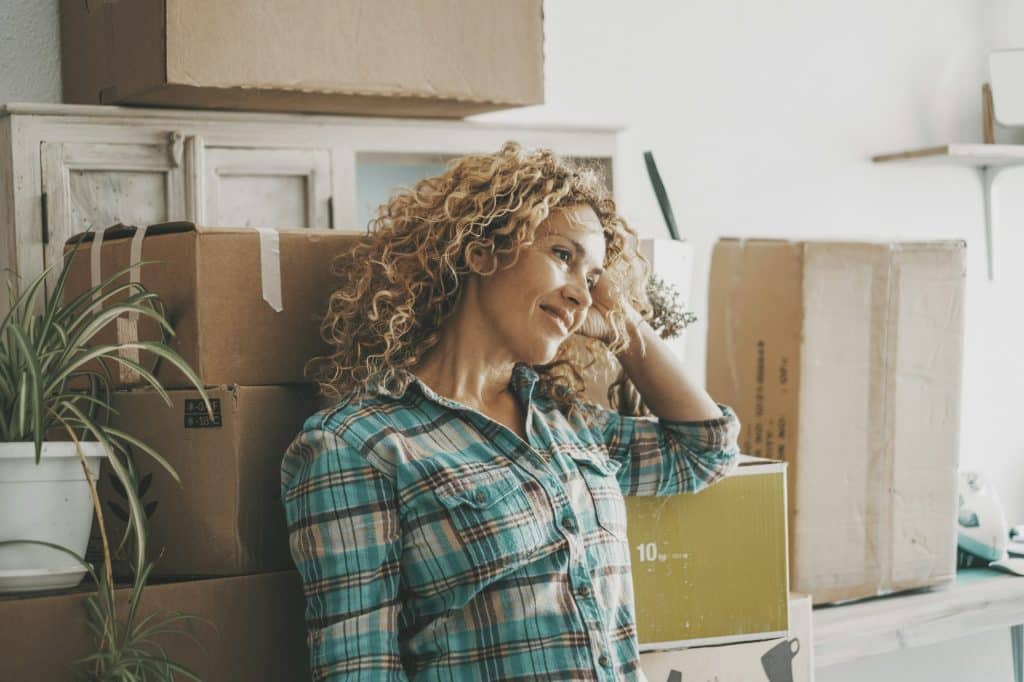 Cute young woman smile and enjoy her new home property after moving and relocating work